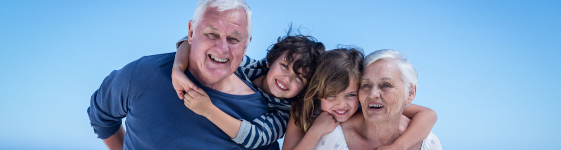 Kids hugging grandparents from behind