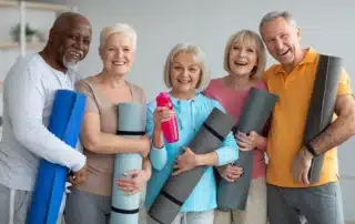 A group of seniors taking advantage of Medicare's silver sneakers fitness program works out in a fitness center.