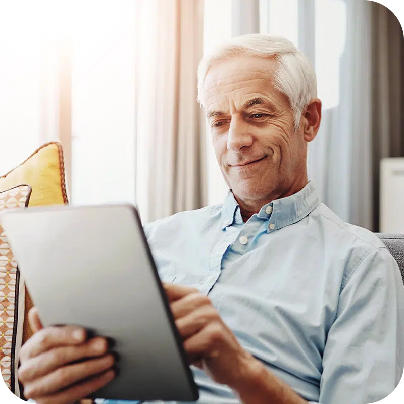 Senior Male looking at Medicare Ebook on Tablet